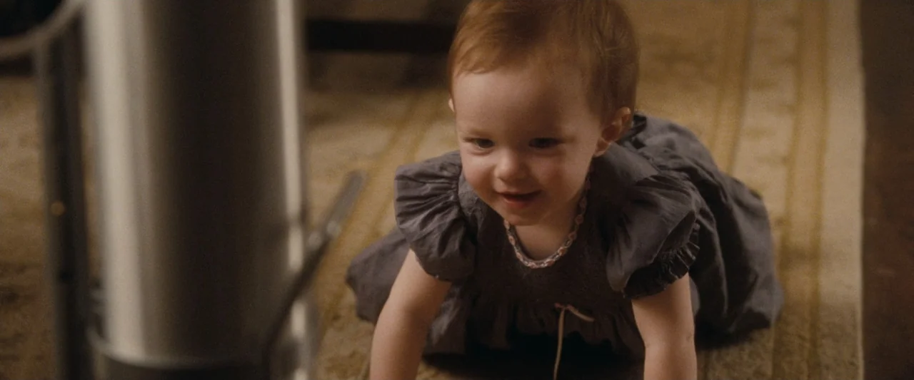 Life As We Know It (2010) movie still: medium — A carpeted floor in a domestic setting features a stainless steel trash can nearby. A baby girl in a…