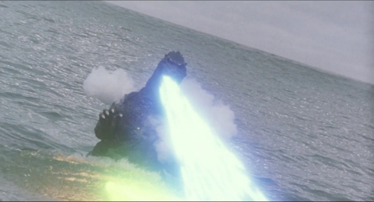 Godzilla vs. Biollante (1989) movie still: wide — A gargantuan monster stands partially submerged in a vast, grey, overcast ocean. The creature…