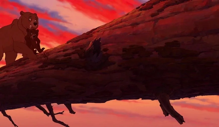 Brother Bear (2003) movie still: wide — A large fallen tree trunk extends diagonally across a vibrant red sunset sky. An adult bear walks carefully…