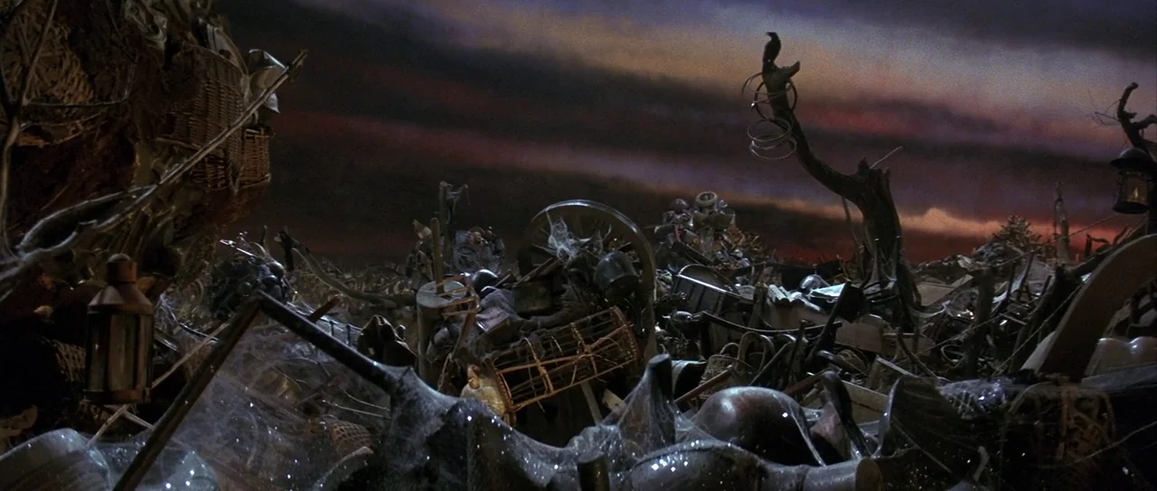 Labyrinth (1986) movie still: establishing — A vast collection of discarded metal objects and old furniture lies in a pile. The dark debris is…
