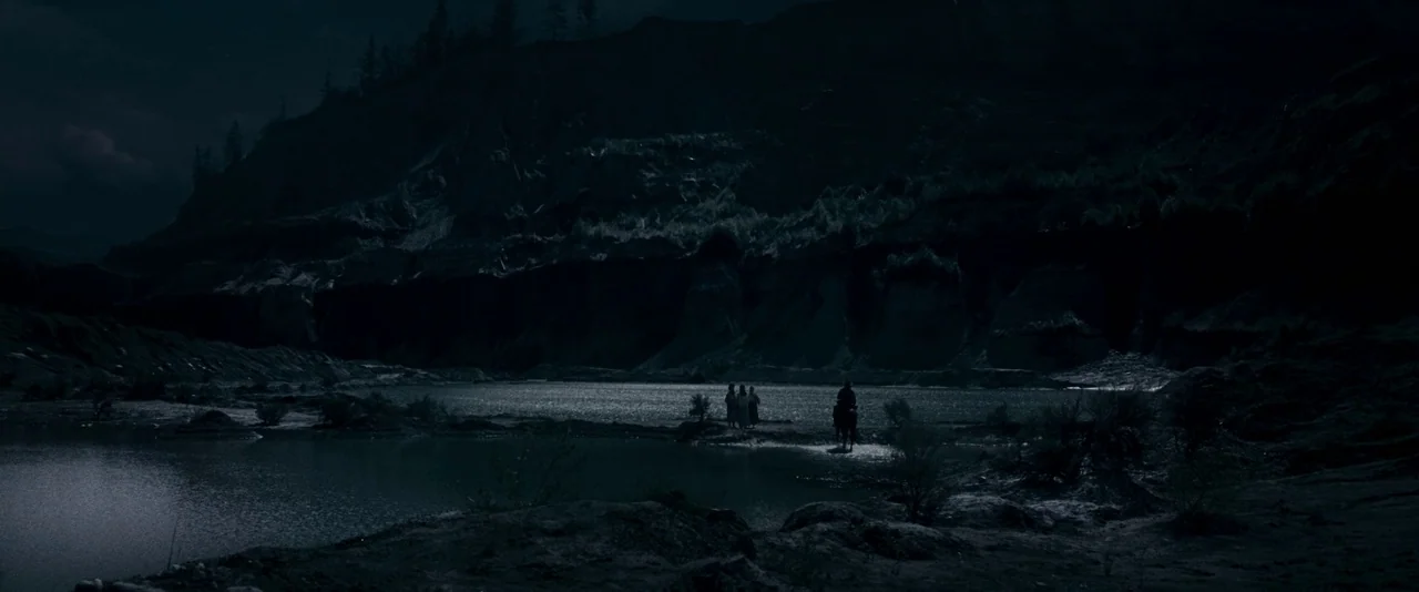 The Twilight Saga: Eclipse (2010) movie still: wide — A dark, craggy quarry contains a deep pool of water under a dim sky. A small group of…