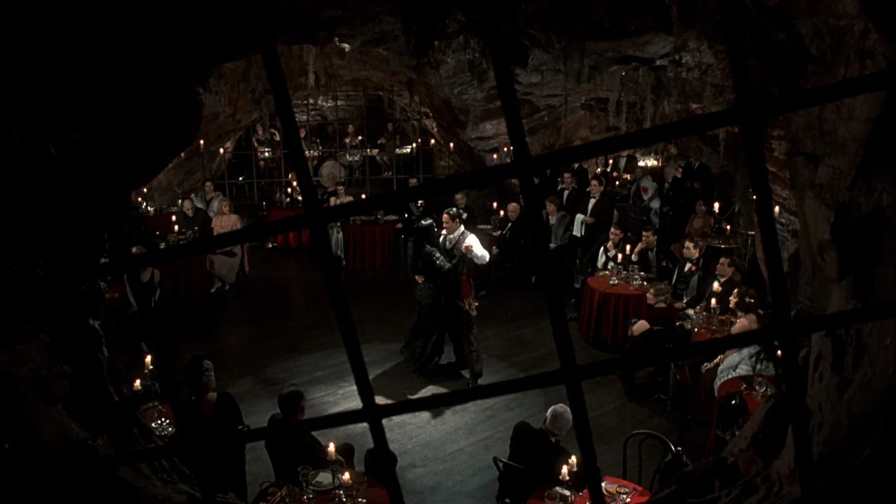 Addams Family Values (1993) movie still: wide — An underground cavern has been converted into a formal ballroom with candlelit dining tables. A…