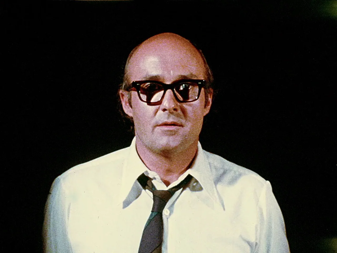 Space is the Place (1974) movie still: closeup — A man stands centered against a deep black, undifferentiated background. He looks directly forward…