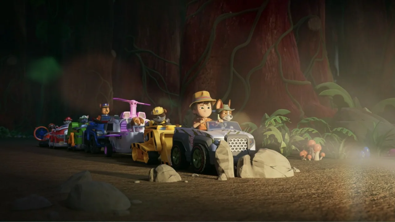 Valiente: A Tracker Story (2025) movie still: wide — A group of stylized animated characters drive small vehicles along a dirt jungle path. Large…