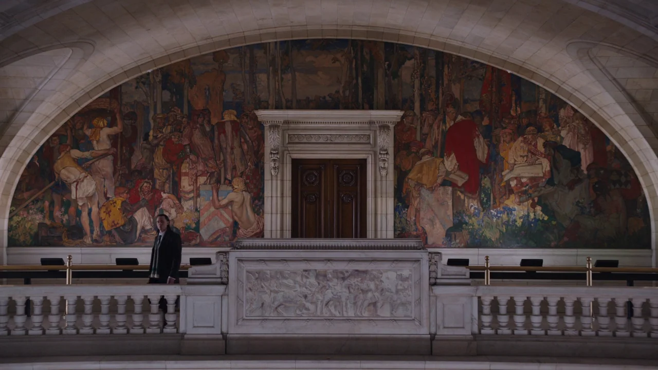 The Avengers (2012) movie still: A lone character stands small against a monumental, sprawling historical mural within the confines of an austere,…
