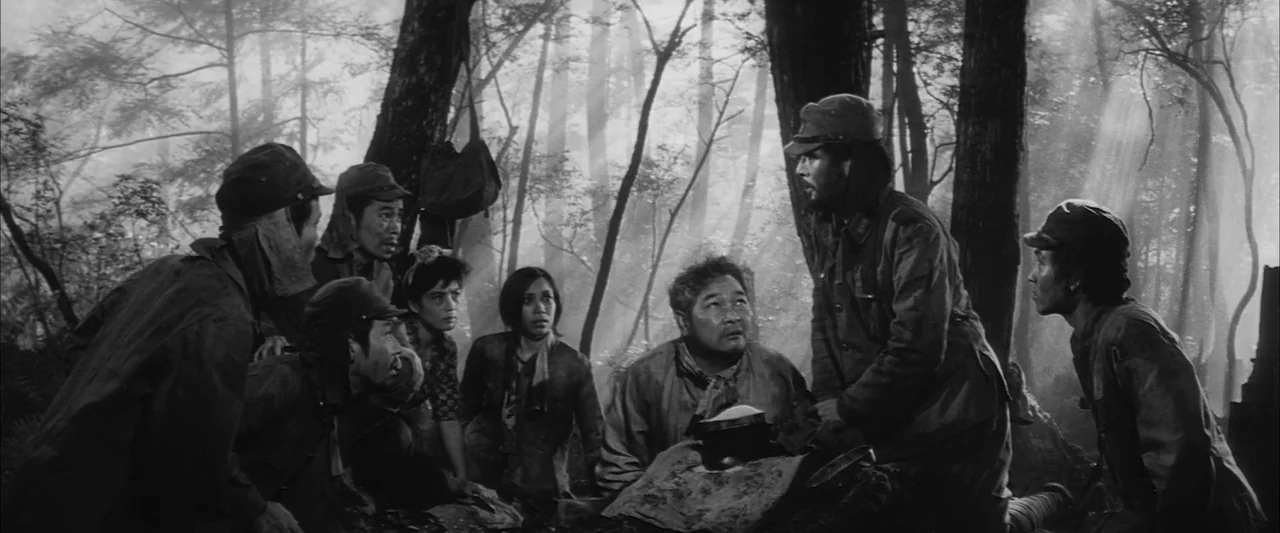 The Human Condition III: A Soldier’s Prayer (1961) movie still: medium — A dense, foggy forest clearing with tall dark tree trunks and dappled…