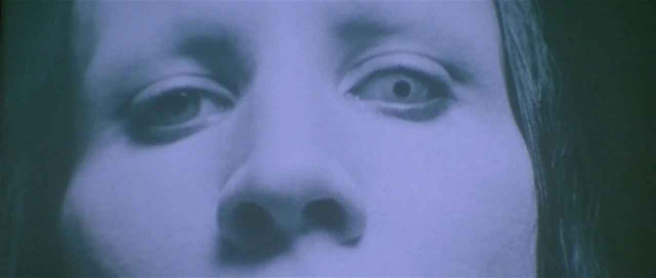Lost Highway (1997) movie still: closeup — A close-up view of a person's eyes and nose in a dark environment. The subject looks directly into the…