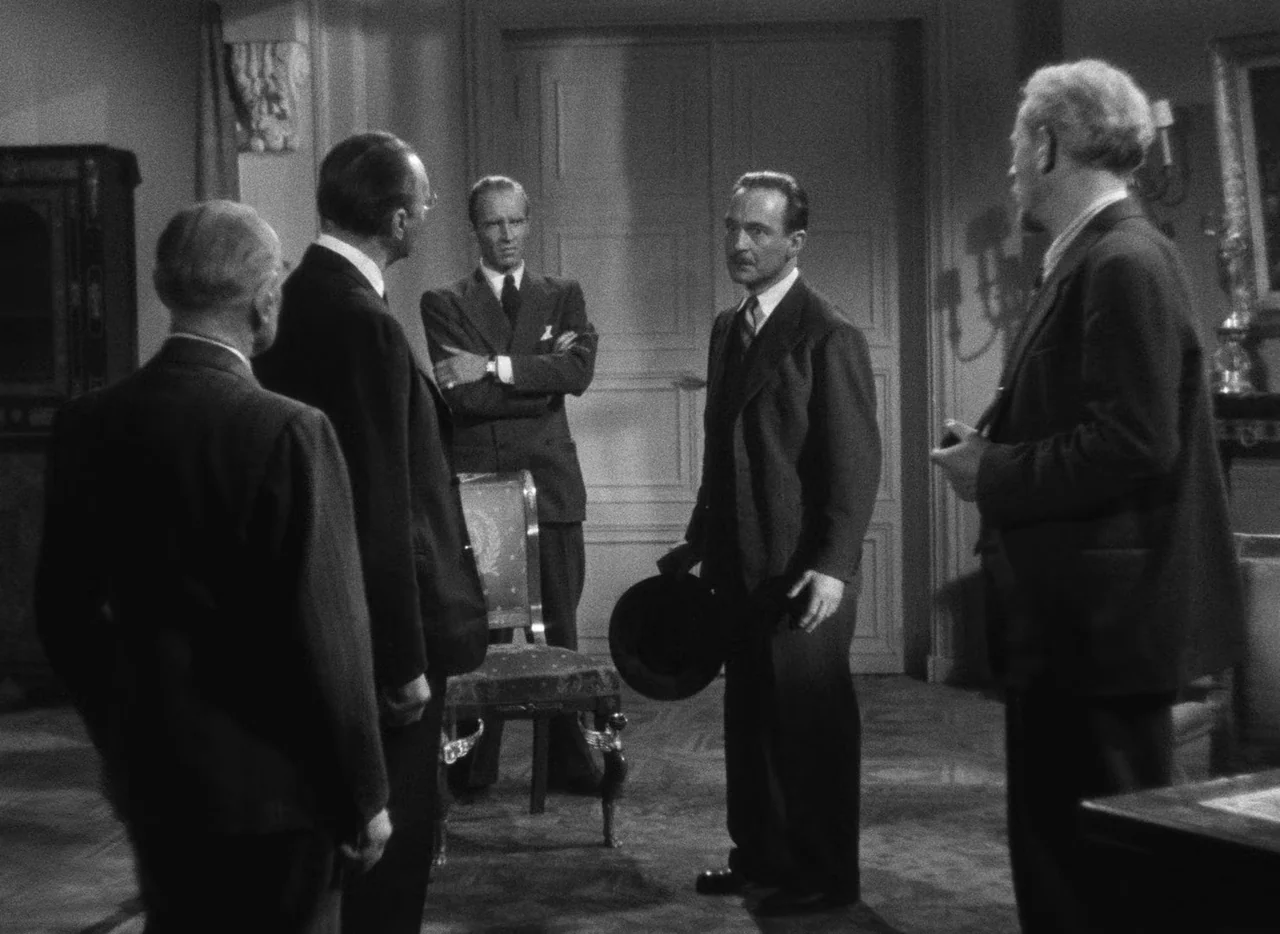 Le Corbeau (1943) movie still: fullbody — A formal study features double doors and a set of chairs arranged centrally. Five men in matching dark…