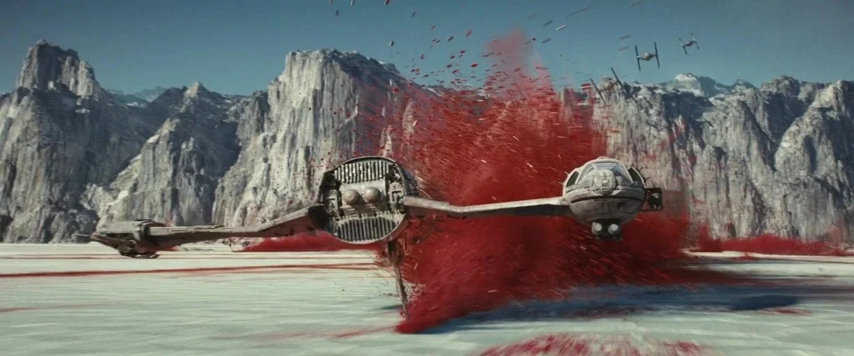 Star Wars: The Last Jedi (2017) movie still: wide — A wide salt flat stretches toward jagged mountains under a clear bright sky. A damaged starship…