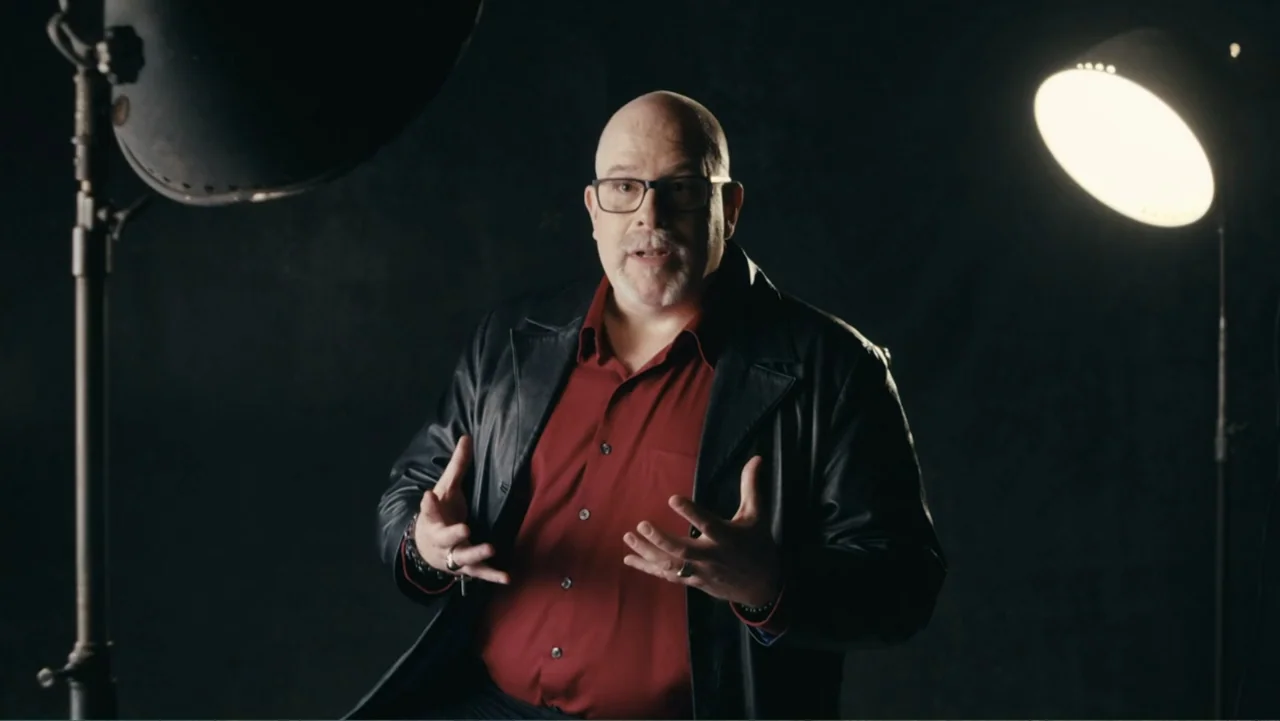 Demon in the White House (2021) movie still: medium — A dark, empty photo studio environment with black backdrop and visible lighting equipment. A…