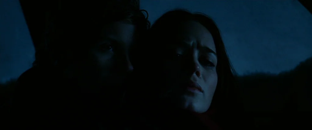 Wind Chill (2007) movie still: closeup — An interior of a dark car at night with two people sitting side by side. The man is partially obscured in…