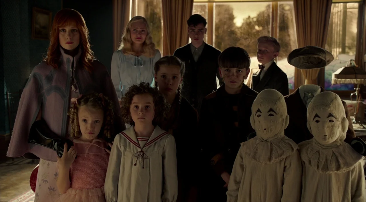 Miss Peregrine’s Home for Peculiar Children (2016) movie still: fullbody — A group of children and a woman stand together inside an old house…
