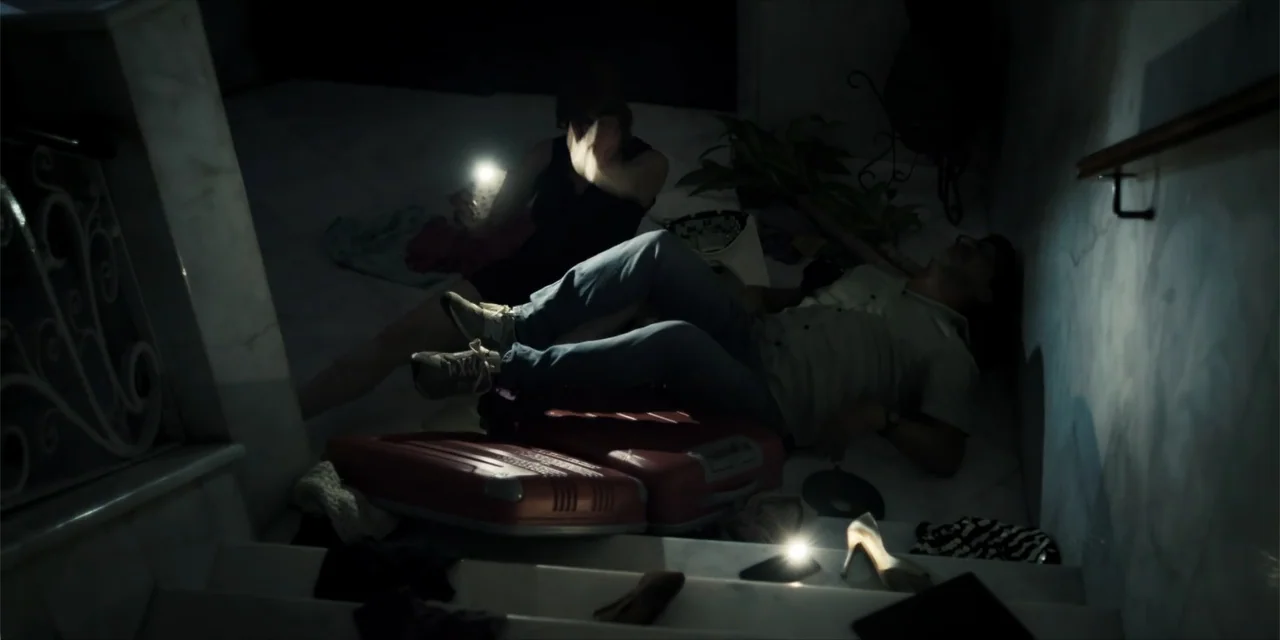 Instant Love (2020) movie still: medium — A dark, marble-floored staircase landing is cluttered with red suitcases and scattered personal items. A…