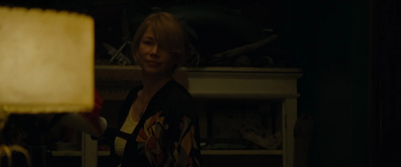 Wonderstruck (2017) movie still: medium — A dimly lit room contains a white shelf holding various small ornaments and models. A woman stands in…