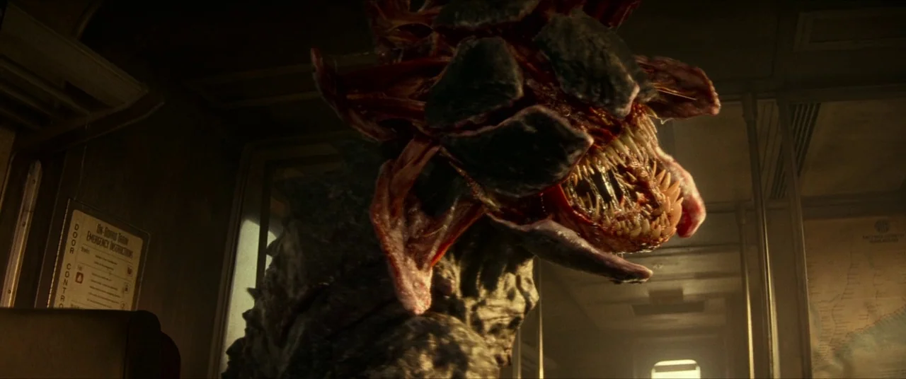 A Quiet Place Part II (2020) movie still: closeup — A dimly lit train car interior features metallic surfaces and an emergency instruction sign. A…