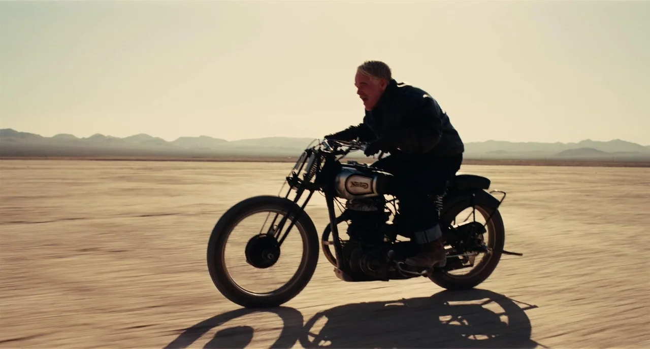 The Master (2012) movie still: fullbody — A vast, barren salt flat stretches out under a clear, pale sky. An older man rides a vintage-style…