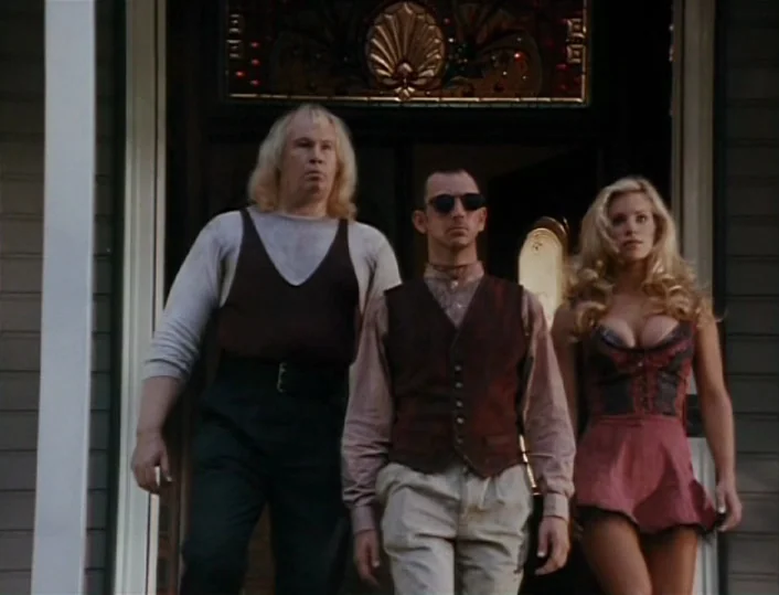 Head of the Family (1996) movie still: fullbody — Three people stand at the entrance of a house with a decorative transom window. The group walks…