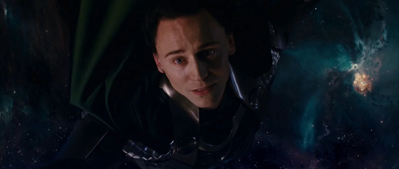 Thor (2011) movie still: closeup — A man drifts through the void of space with a swirling nebula in the distance. The figure wears metallic armor…