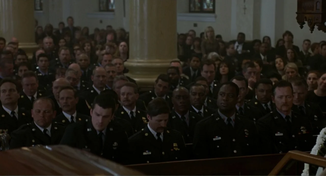 Ladder 49 (2004) movie still: medium — A crowded interior of a church with rows of people seated in wooden pews. Many uniformed police officers sit…