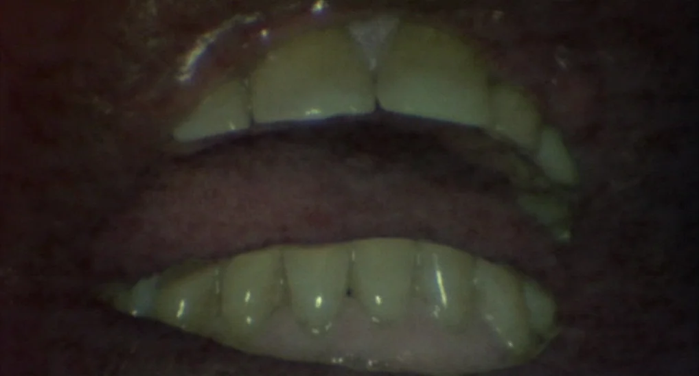 Twin Peaks: Fire Walk With Me (1992) movie still: closeup — A close-up view focuses on human teeth and the surface of a tongue. The mouth is…
