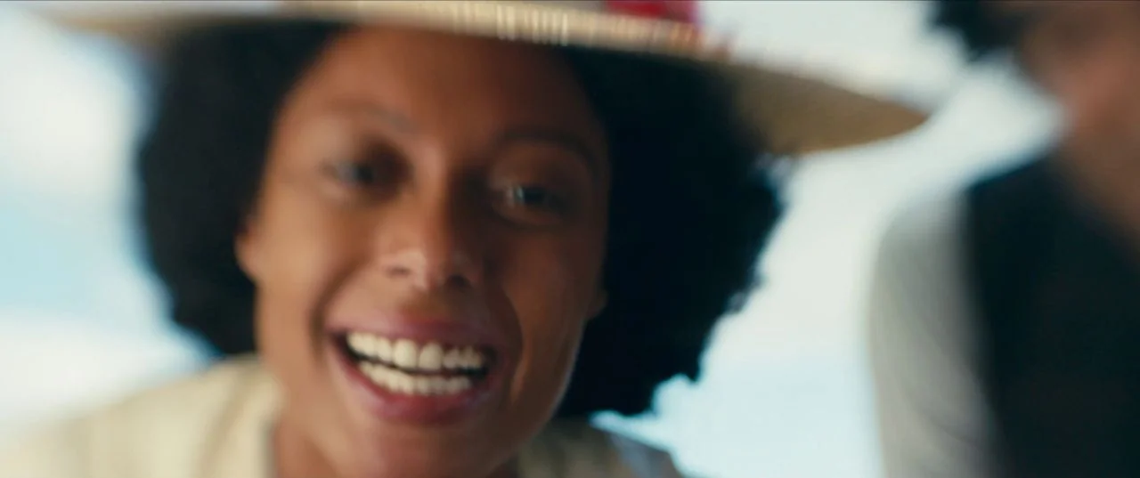 The Personal History of David Copperfield (2019) movie still: closeup — A close-up shot captures a person wearing a straw hat against a bright…