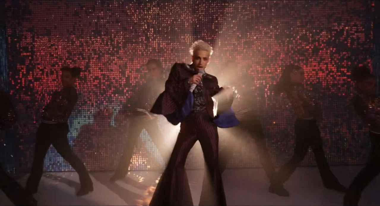 Henry Danger: The Movie (2025) movie still: fullbody — A stage set features a wall of shimmering red sequins as the primary background element. A…