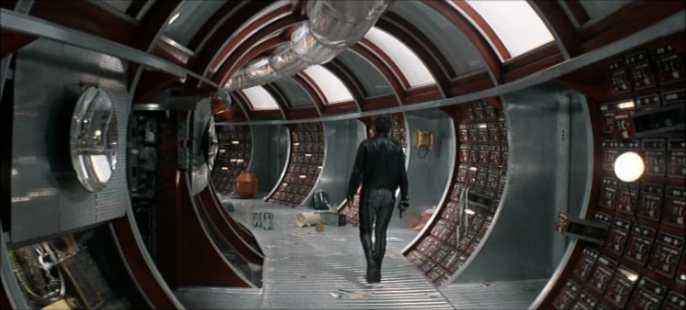 Solaris (1972) movie still: fullbody — A curved spaceship corridor features metallic walls lined with numerous small red control buttons. A lone man…