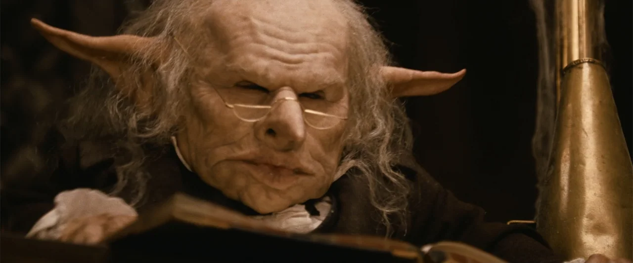 Harry Potter and the Philosopher's Stone (2001) movie still: closeup — A dimly lit indoor workspace features a textured wooden surface and antique…