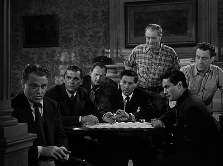 White Heat (1949) movie still: medium — A dimly lit room with wallpapered walls displays a formal mid-century residential aesthetic. Six men gather…