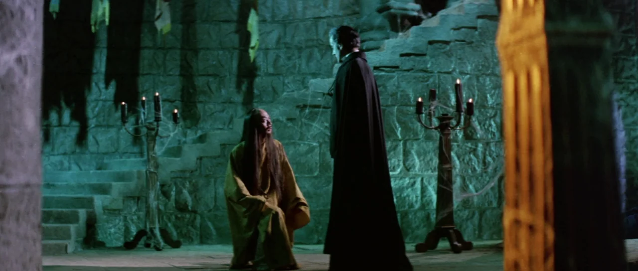 The Legend of the 7 Golden Vampires (1974) movie still: wide — A stone chamber with rough masonry walls and cobwebs features a stone staircase. A…