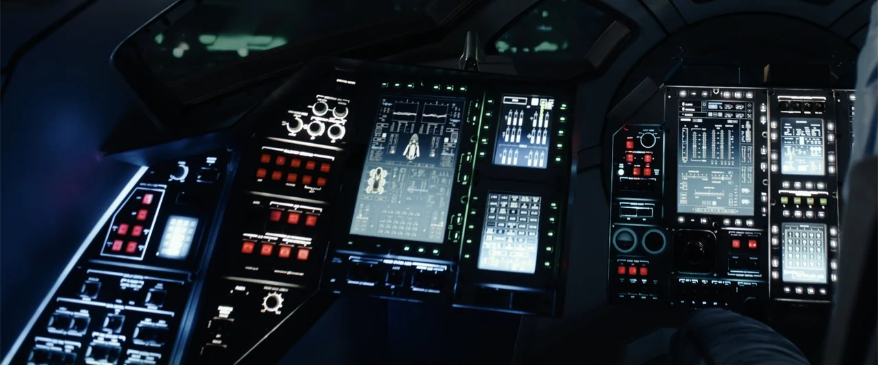 Moonfall (2022) movie still: medium — A high-tech cockpit interior contains complex instrument consoles with glowing digital screens and buttons.…
