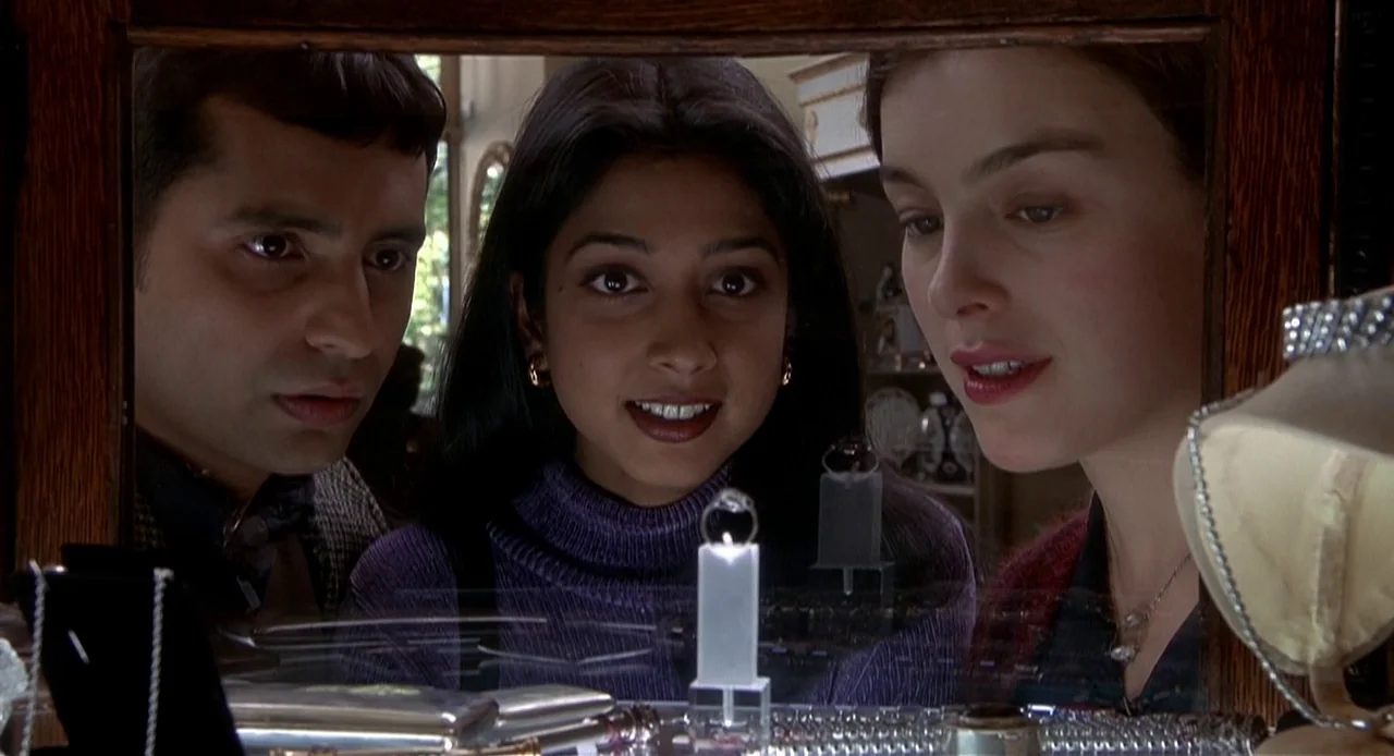 The Sixth Sense (1999) movie still: medium — A jewelry store display case holds several rings on pedestals behind glass. Three young adults stand…