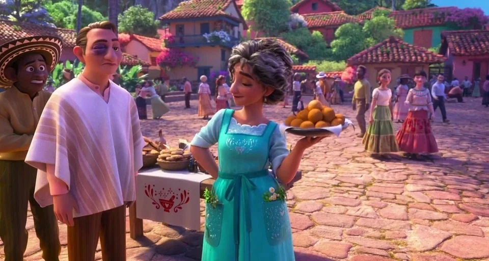 Encanto (2021) movie still: medium — A sunny village square paved with irregular stones features traditional stucco houses in the background. A…