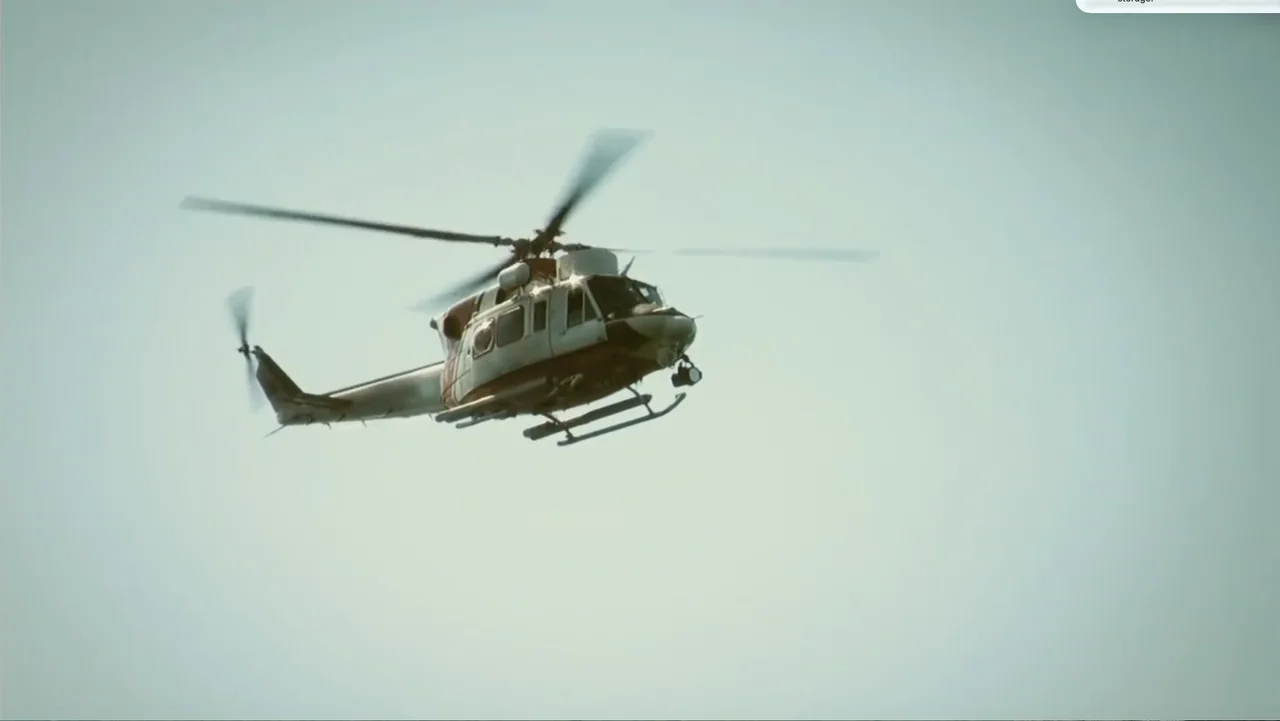 National Parks Adventure (2016) movie still: wide — A rescue helicopter flies against a featureless, light-colored overcast sky. The vehicle is…
