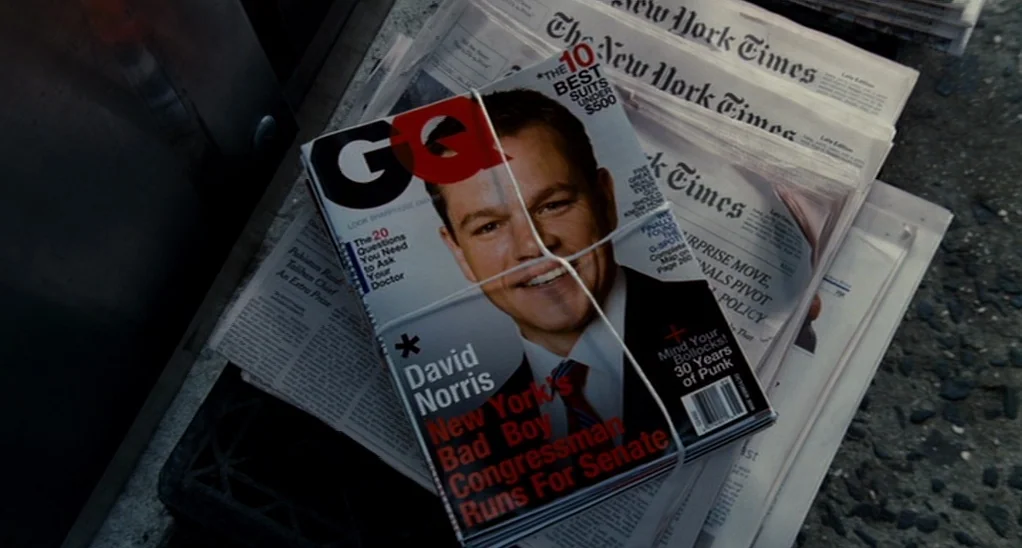 The Adjustment Bureau (2013) movie still: closeup — A stack of newspapers and a GQ magazine are bundled together with string. The magazine cover…