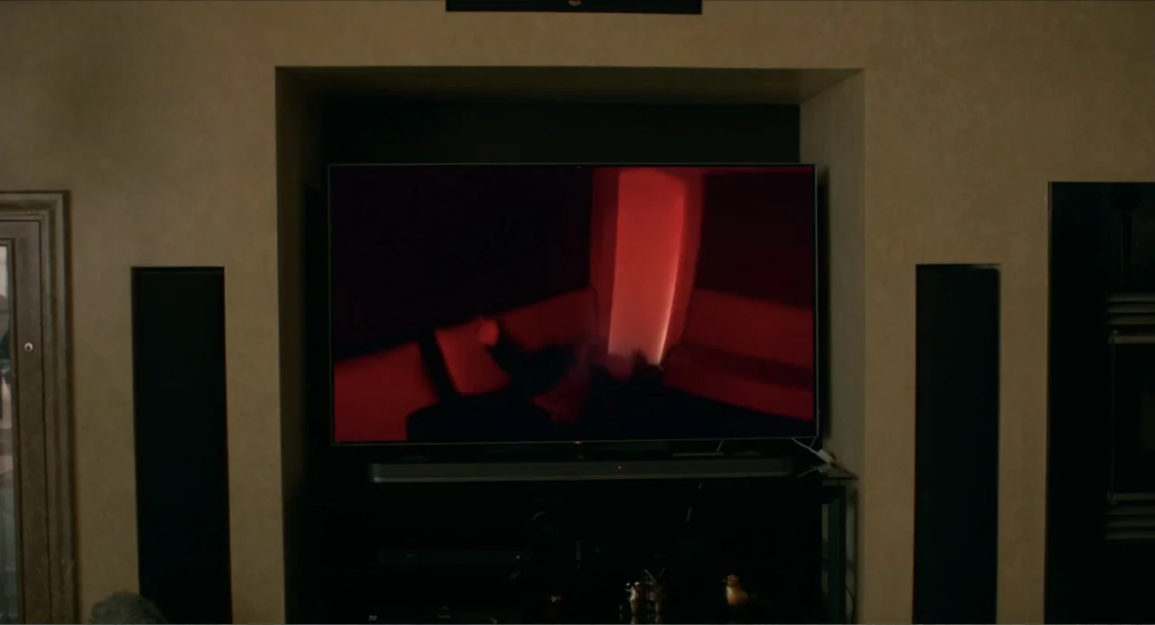 Instantes Capturados (2022) movie still: medium — A flat-screen television is mounted in a recessed wall area above a media console. The screen…