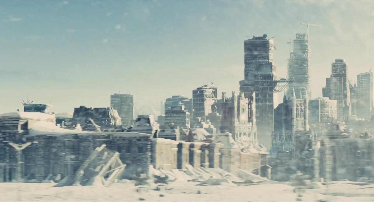 Snowpiercer (2013) movie still: establishing — A sprawling cityscape lies in ruins under a blanket of heavy winter snow. Tall, partially destroyed…