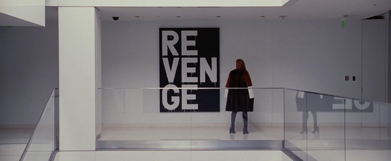 Nocturnal Animals (2016) movie still: wide — A modern, minimalist art gallery with white walls and a glass railing. A woman stands in front of a…
