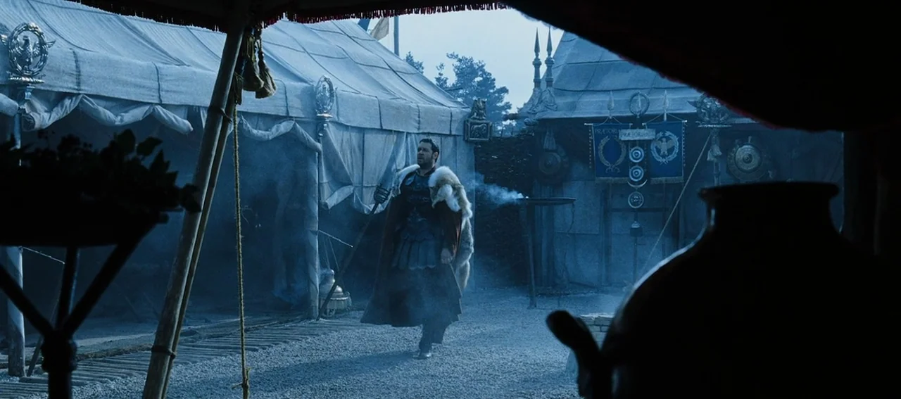 Gladiator (2000) movie still: wide — A Roman military encampment features large canvas tents with banners and metal standards. A man in ancient…