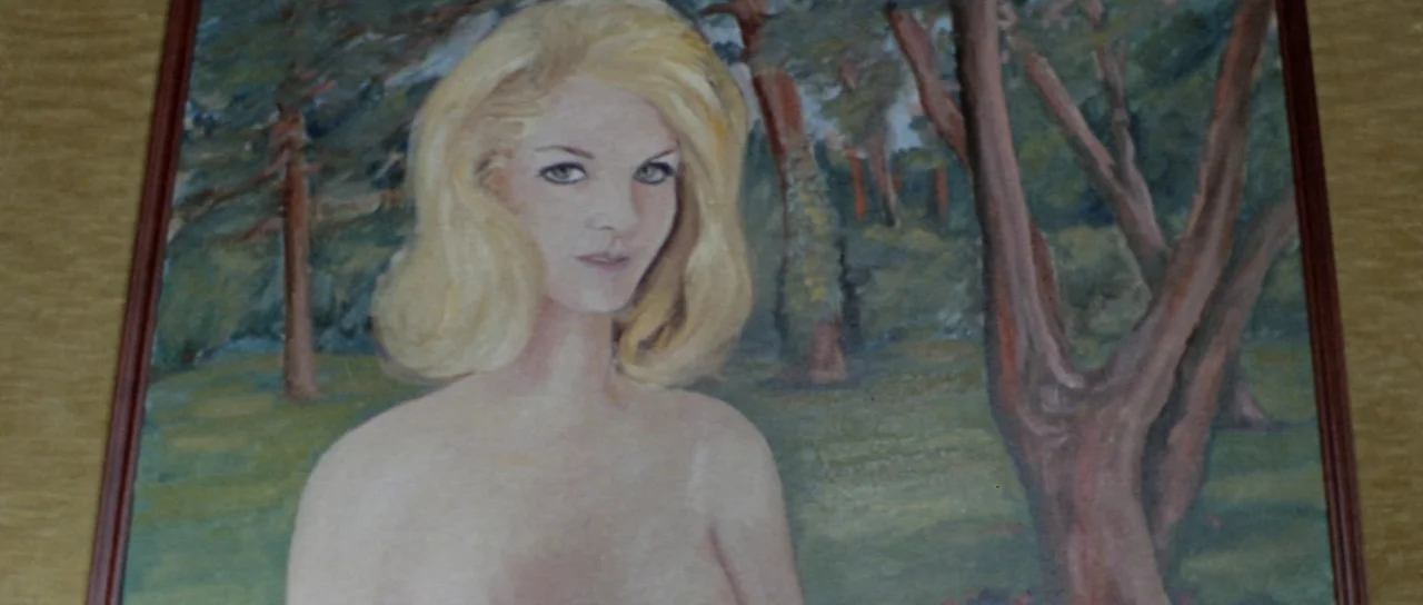 Orgasmo (1969) movie still: medium — A framed oil painting depicts a young blonde woman standing in an outdoor landscape. The woman faces forward…