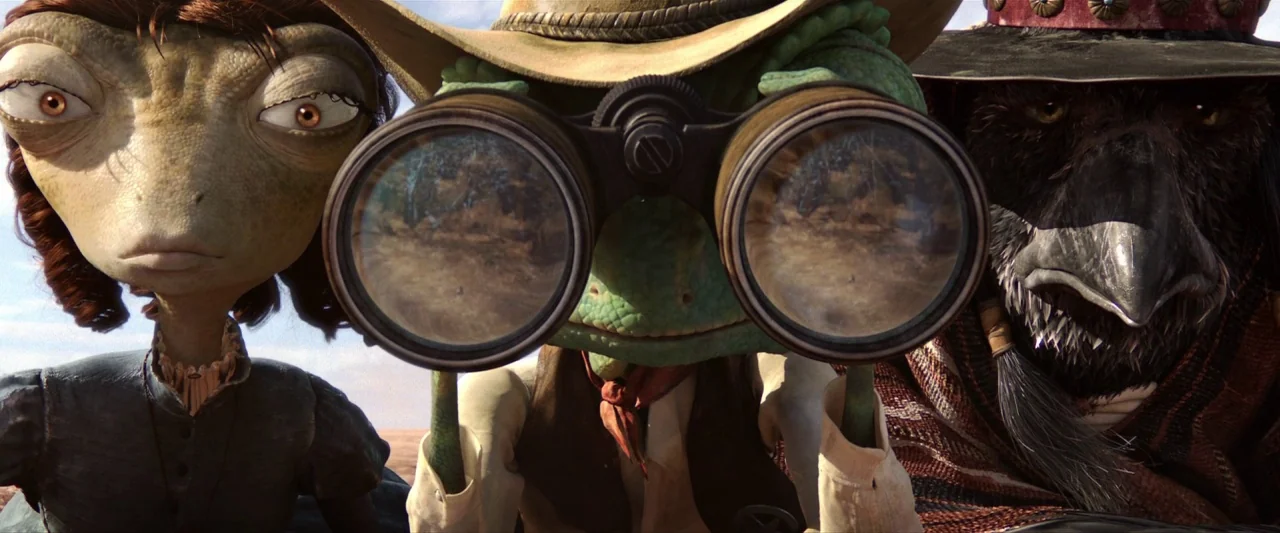 Rango (2011) movie still: medium — Three anthropomorphic desert creatures stand in an arid, open landscape under bright light. A lizard, a…