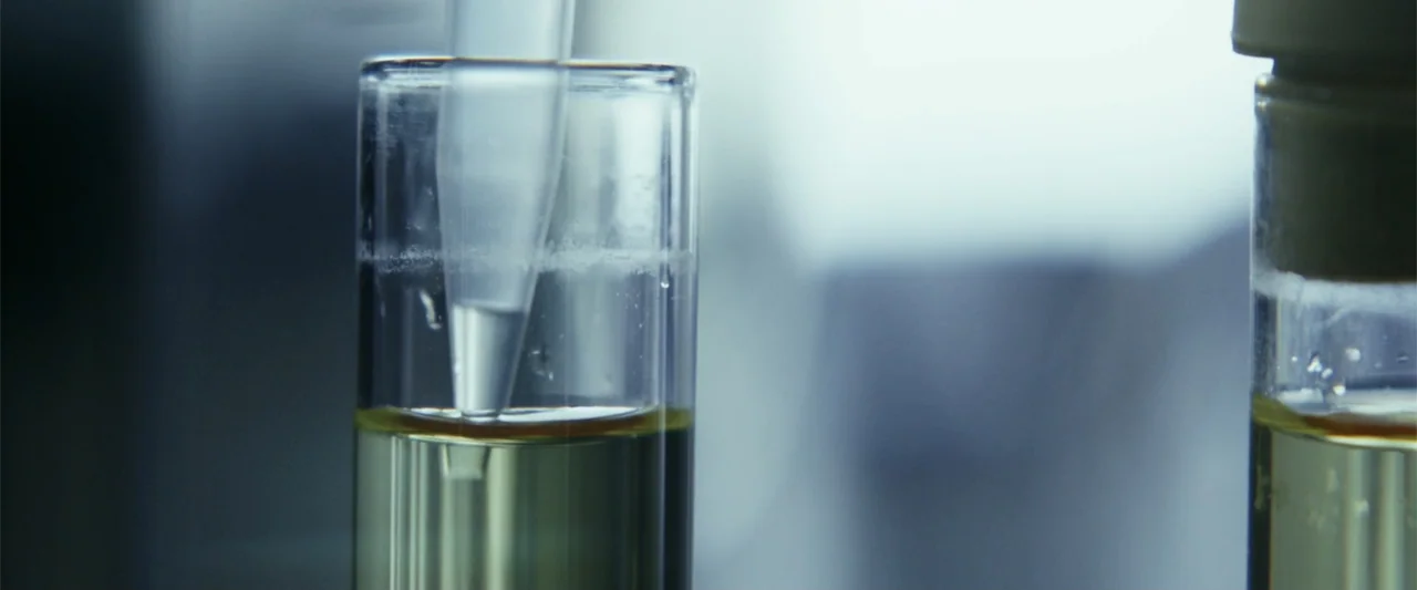 The Tomorrow War (2021) movie still: closeup — A close-up view shows laboratory glassware containing a translucent yellowish chemical fluid. A…