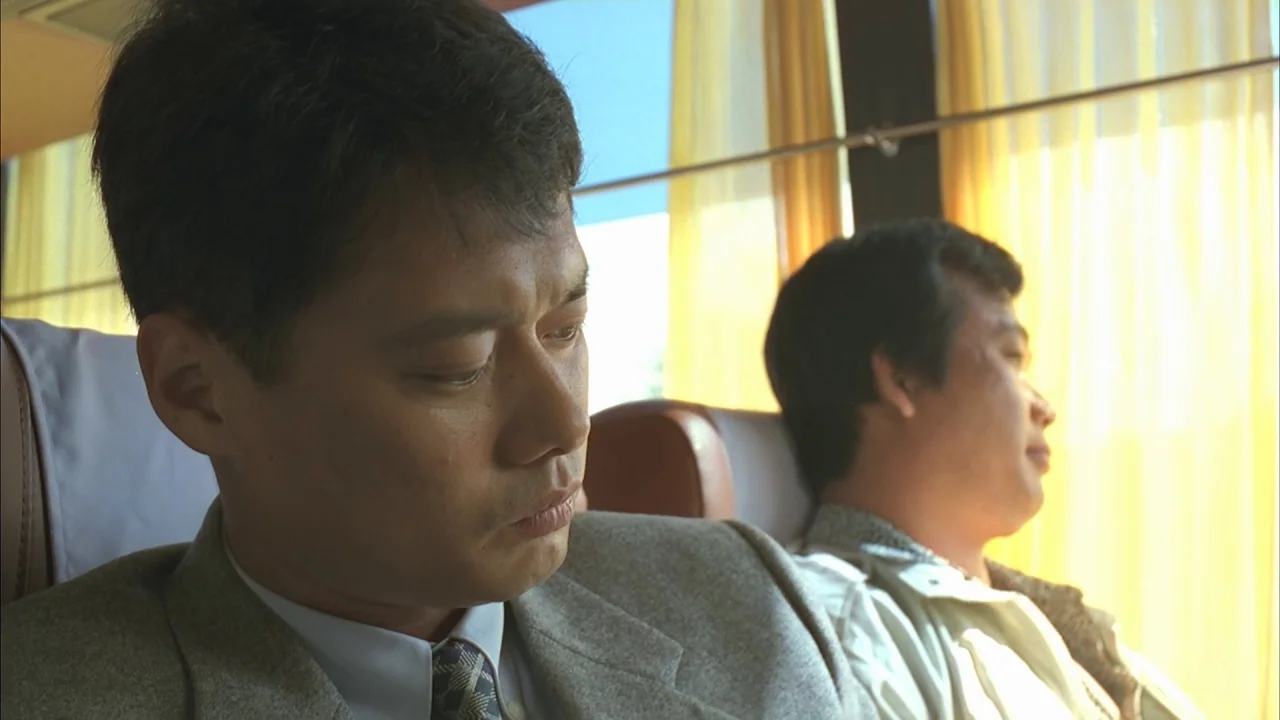 The Day a Pig Fell Into the Well (1996) movie still: medium — The interior of a bus features rows of soft, light-colored seats and yellow curtains.…