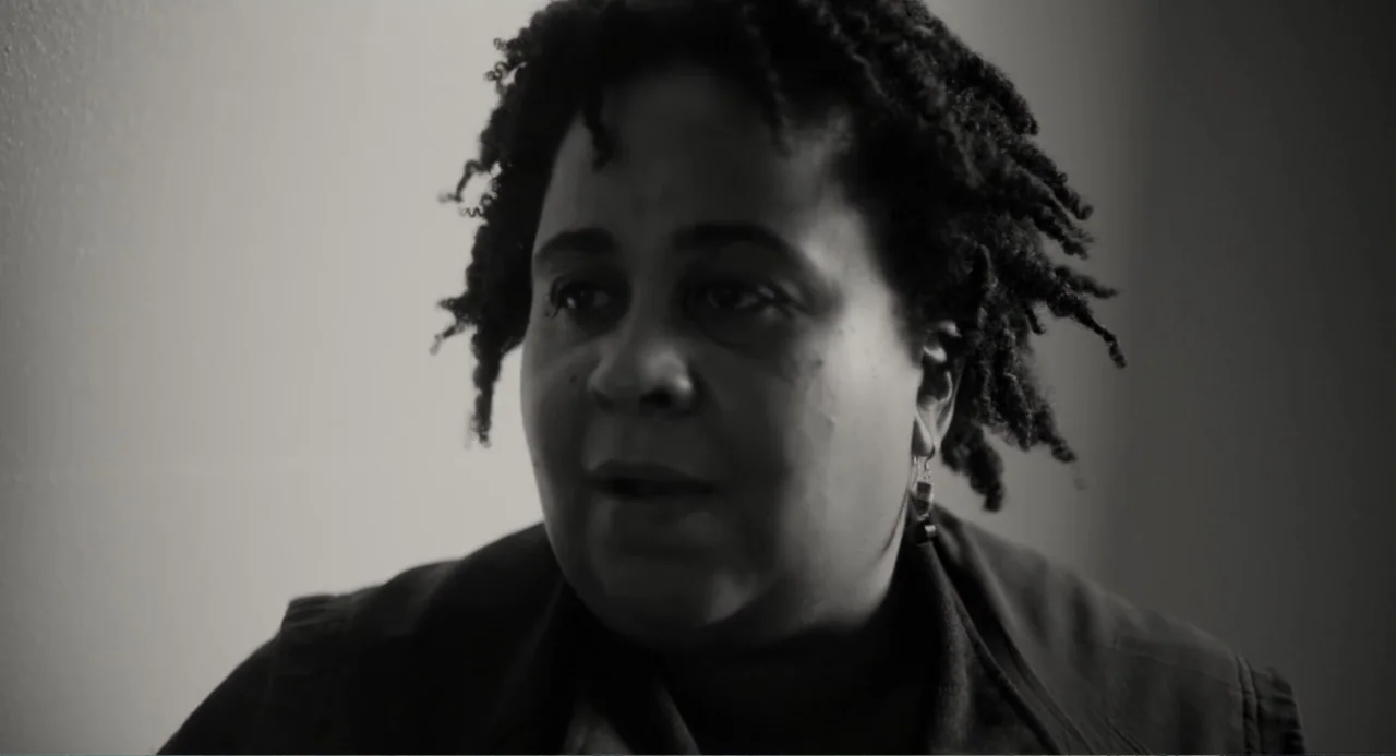What You Gonna Do When the World's on Fire? (2019) movie still: closeup — An interior space with a plain, light-colored wall visible behind the…