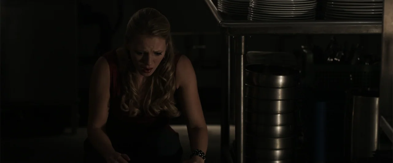 Final Destination 5 (2011) movie still: medium — A dimly lit industrial food preparation area contains stacks of stainless steel bowls. A young…