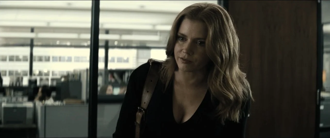 Batman v Superman: Dawn of Justice (2016) movie still: medium — A modern office environment with black-framed glass partitions and cubicle…