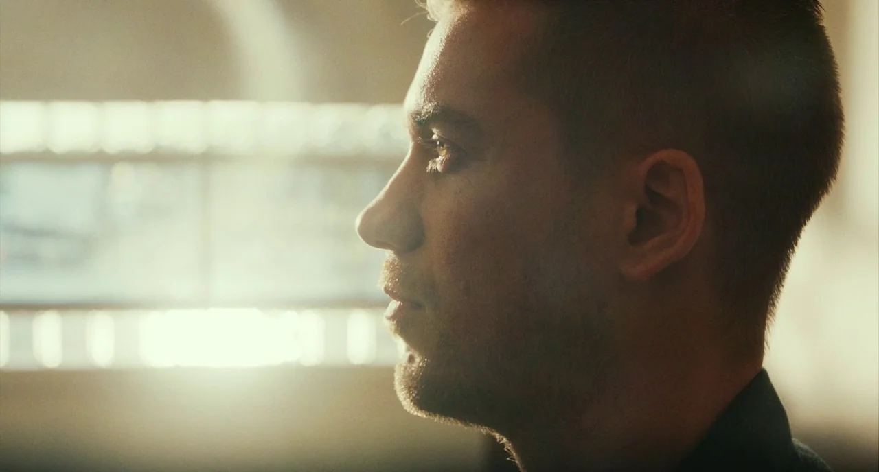 Blindspotting (2018) movie still: closeup — A side profile of a man is illuminated by bright natural window light. The background is a soft,…