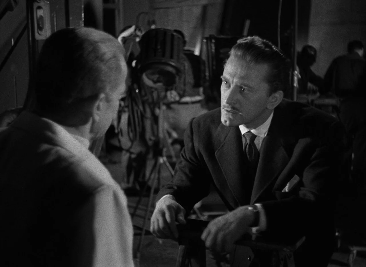 The Bad and the Beautiful (1952) movie still: medium — A dark indoor area cluttered with professional film production equipment and lighting stands.…