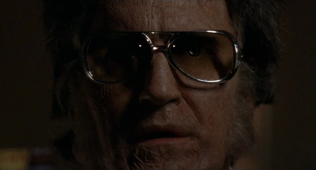 Bubba Ho-Tep (2002) movie still: closeup — A dimly lit room provides a dark background for the close-up portrait. An older man with wrinkles and…