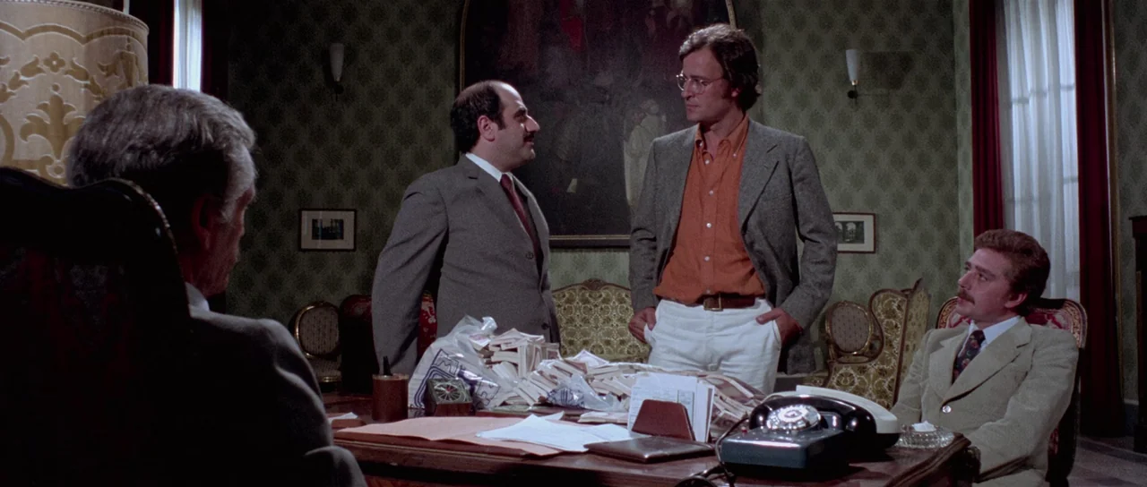The Suspicious Death of a Minor (1975) movie still: medium — A wood-paneled room features patterned wallpaper and a large oil painting on the wall.…